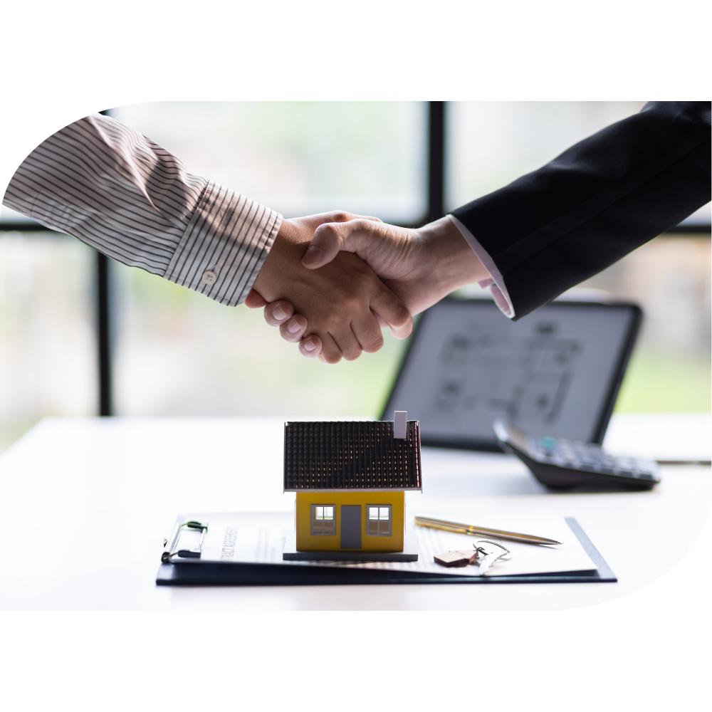 Businessmen shaking hands above a house sale agreement-1