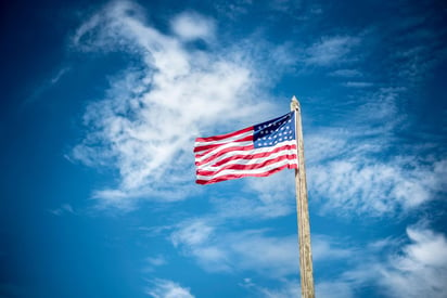 An American flag against a deep blue sky