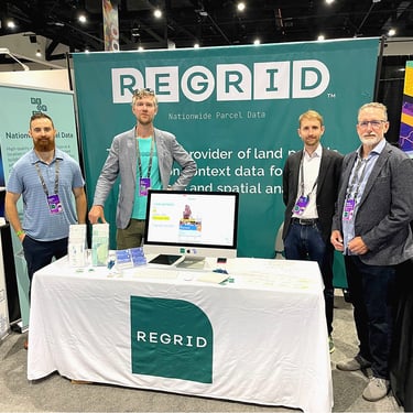 The Regrid Team stands around the Regrid booth at the Esri UC 2022